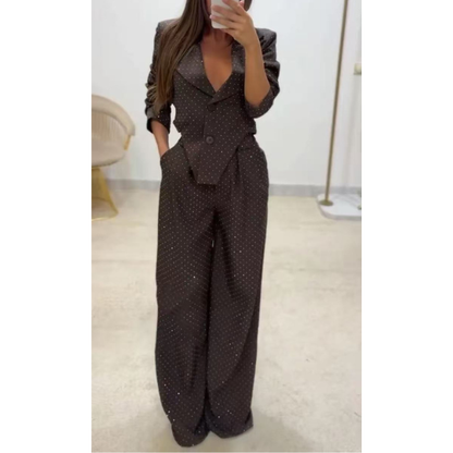 Blizgus asimetrinio švarkelio ir platėjančių kelnių kostiumėlis