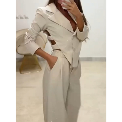 Blizgus asimetrinio švarkelio ir platėjančių kelnių kostiumėlis