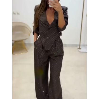 Blizgus asimetrinio švarkelio ir platėjančių kelnių kostiumėlis